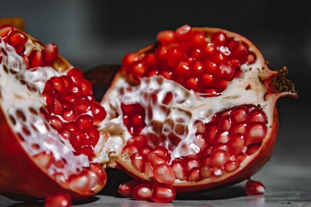 A pomegranate cut open, revealing the red arils (seeds) inside.