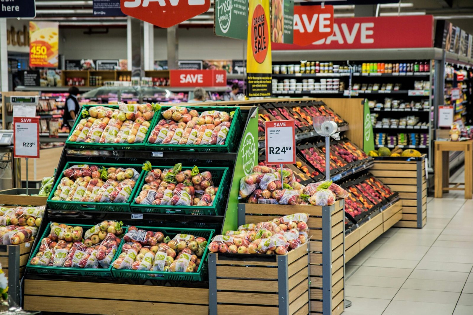 The produce section of a grocery store, with apples and other fruits on display.